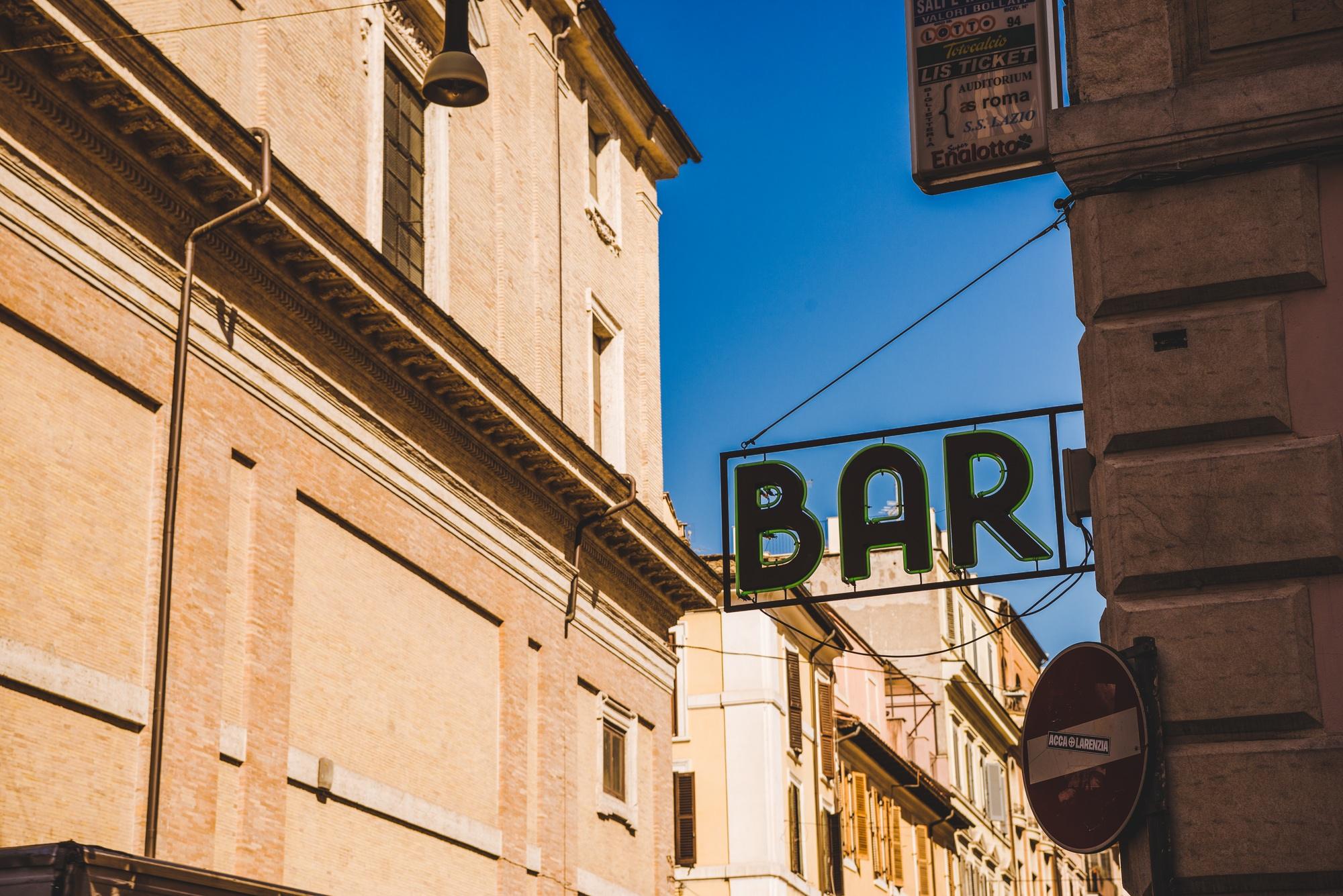 ROME, ITALY - 10 MARCH 2018: bar sign with ancient buildings on background